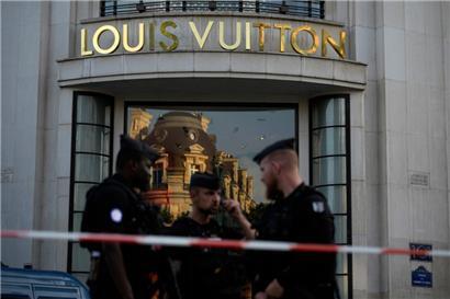 Polizisten stehen nach einer Messerattacke vor dem Louis Vuitton-Geschäft auf der Avenue des Champs-Elysees Wache
