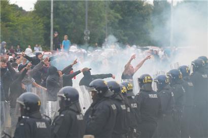 Polizisten stehen vor Randalierern bei gewalttätigen Auseinandersetzungen auf einer Anti-Einwanderungsdemonstration vor dem Holiday Inn Express Hotel, in dem Asylbewerber untergebracht sind
