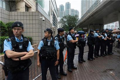 Polizisten stehen vor dem West Kowloon Magistrates‘ Courts in Hongkong Wache
