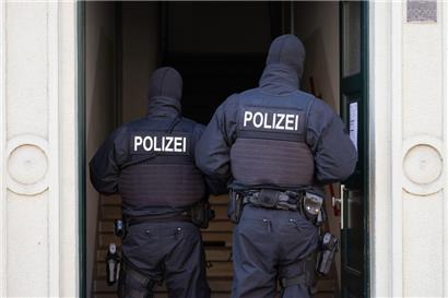 Polizisten stehen während einer Razzia gegen mutmaßliche Rechtsextreme in einem Hauseingang im Dresdner Stadtteil Cotta
