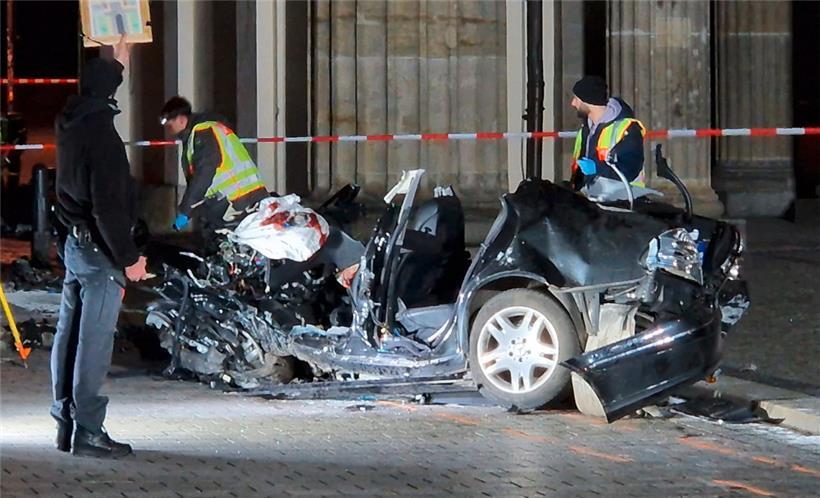 Polizisten untersuchen das Fahrzeugwrack vor dem Brandenburger Tor am frühen Montagmorgen
