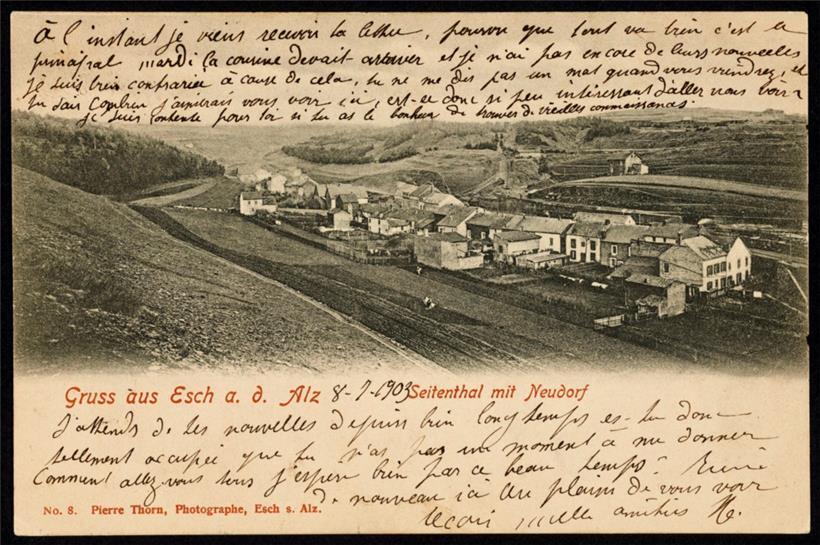 Postkarte aus dem Jahr 1903 mit einer Ansicht des Escher Fotografen Pierre Thorn des Neudorfs, mit vorne dem Lallingerberg und hinten Schneier-Ostberg und Galgenberg. Die ersten Häuser in der rue de Neiduerf und der rue de Rumelange sind gut zu sehen, ebenso wie die Schräglage (der Bremsberg zu Förderung und Abtransport des Eisenerzes) der Collart-Mine,…
