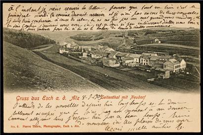 Postkarte aus dem Jahr 1903 mit einer Ansicht des Escher Fotografen Pierre Thorn des Neudorfs, mit vorne dem Lallingerberg und hinten Schneier-Ostberg und Galgenberg. Die ersten Häuser in der rue de Neiduerf und der rue de Rumelange sind gut zu sehen, ebenso wie die Schräglage (der Bremsberg zu Förderung und Abtransport des Eisenerzes) der Collart-Mine,…
