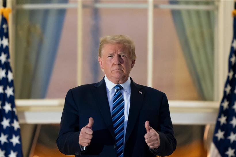 Präsident Donald Trump streckt die Daumen hoch, auf dem Balkon vor dem Blue Room, als er am Montag, ins Weiße Haus in Washington zurückkehrt, nachdem er das Walter Reed National Military Medical Center in Bethesda, Md. verlassen hat. 
