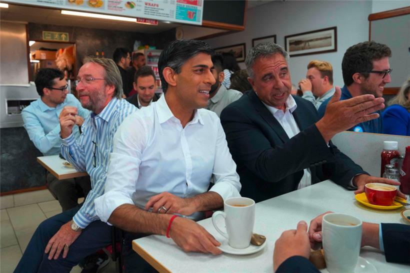 Premierminister Rishi Sunak (M.) sitzt mit dem frisch gewählten Tory-Politiker Steve Tuckwell (r.) in einem Café in Ruislip, wo dieser den Wahlkreis Uxbridge and South Ruislip des früheren Premiers Boris Johnson verteidigen konnte
