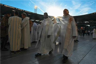 Priester versammeln sich vor dem Auftritt von Papst Franziskus auf dem Feld eines Fußballstadions in Brüssel
