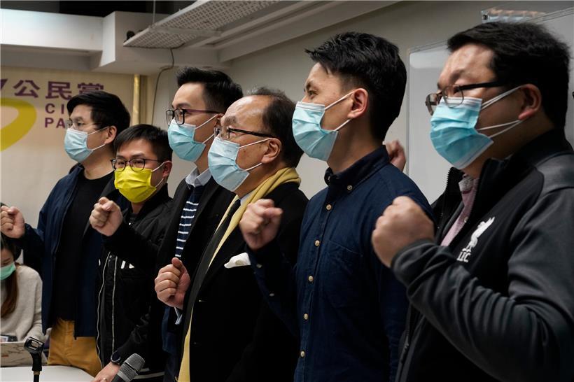 Pro-demokratische Parteimitglieder tragen Mund-Nasen-Schutz und rufen Parolen während einer Pressekonferenz in Hongkong. Rund 50 pro-demokratische Aktivisten und frühere Abgeordnete sind in der Stadt wegen angeblicher Verstöße gegen das neue Sicherheitsgesetz festgenommen worden.
