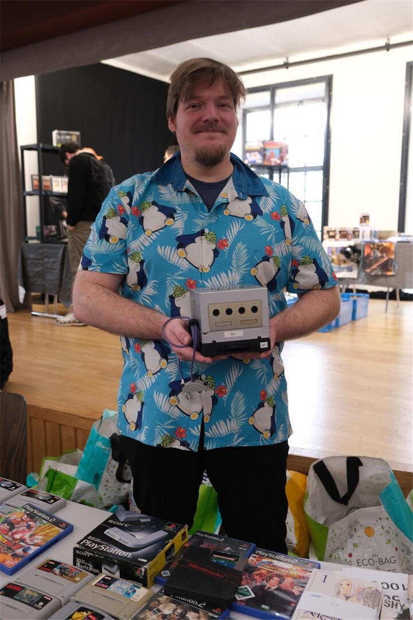 Rafael Kauffmann hält Nintendo GameCube mit angeschlossenem Game-Boy-Player, Retro-Gaming Technik aus den frühen 2000ern