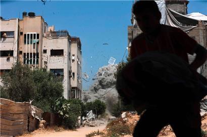 Rauch und Trümmerteile eines Hauses fegen nach einem iraelischen Schlasg Ende Mai durch die Straßen des al-Tuffah-Viertels in Gaza-Stadt.
