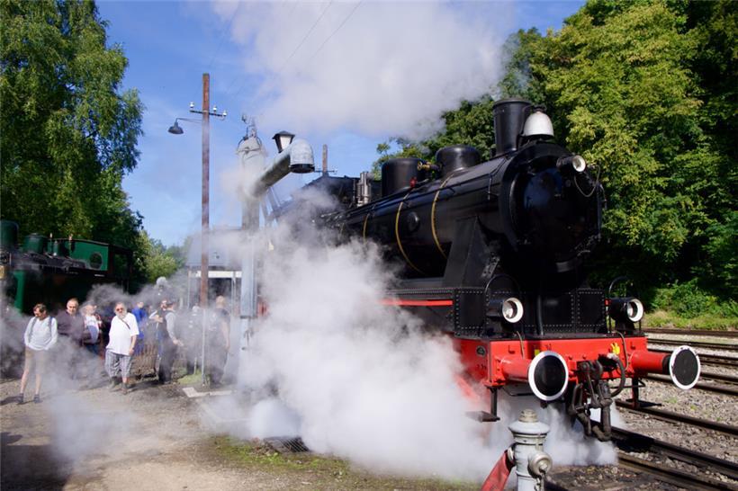 Rauchschwaden legen sich über das Tal, während die Lok pfeifend losfährt
