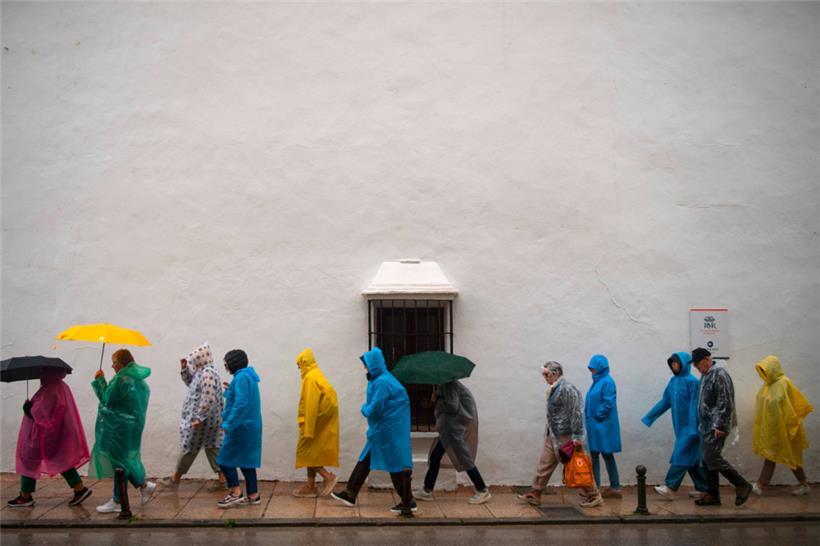 Regen statt Sonne in der südspanischen Stadt Ronda im März: Touristen waren mit Regenschirmen und -westen unterwegs 
