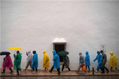 Regen statt Sonne in der südspanischen Stadt Ronda im März: Touristen waren mit Regenschirmen und -westen unterwegs 
