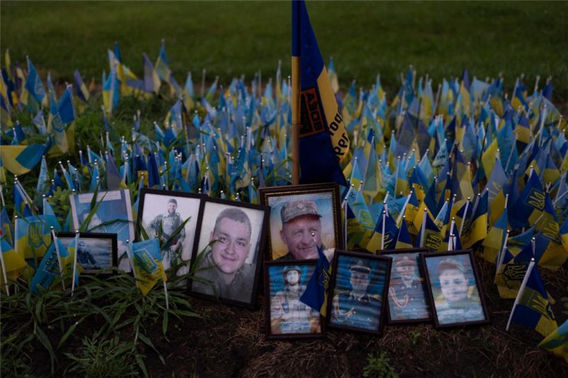 Regentropfen liegen auf Fotos von ukrainischen Soldaten, die im Krieg Russlands gegen die Ukraine gefallen sind, an einer Gedenkstätte zu Ehren der gefallenen Soldaten nahe Kiew
