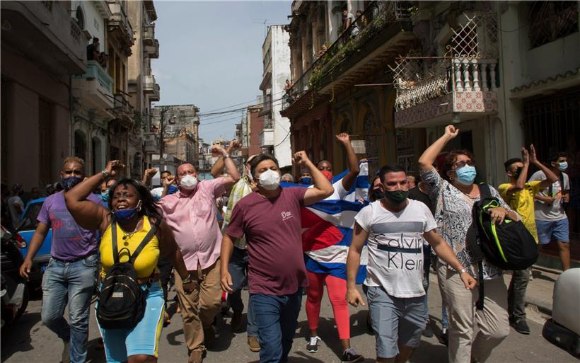 Regierungsanhänger rufen Slogans, während regierungskritische Demonstranten in Havanna, Kuba marschieren. Hunderte von Demonstranten sind in mehreren Städten Kubas auf die Straße gegangen, um gegen die anhaltende Lebensmittelknappheit und die hohen Preise für Lebensmittel zu protestieren. 
