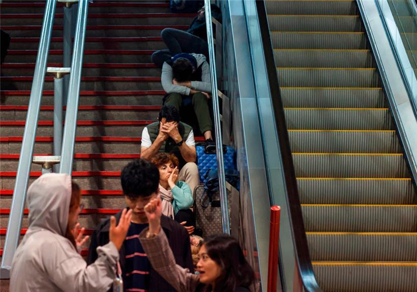 Reisende am Bahnhof warten auf Züge, die nicht mehr fahren
