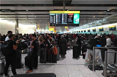 Reisende warten wegen einer Cyberattacke am 20. September 2025 im Terminal 4 des Flughafens Heathrow westlich von London

