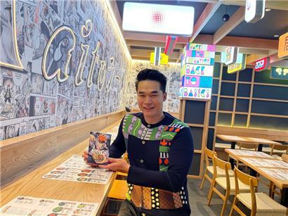 Restaurantinhaber Dali Zhu zeigt ein Heftchen vom Kaito-Manga

