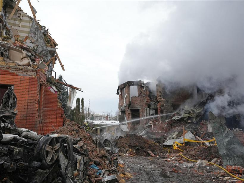 Rettungskräfte löschen Feuer nach russischem Angriff in urbanem Gebiet bei Tag