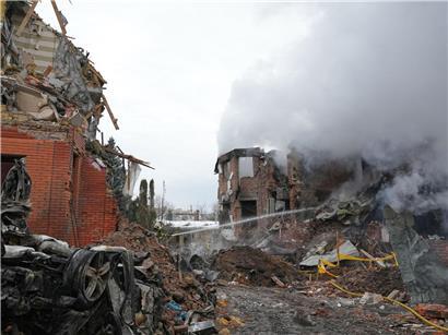Rettungskräfte löschen Feuer nach russischem Angriff in urbanem Gebiet bei Tag