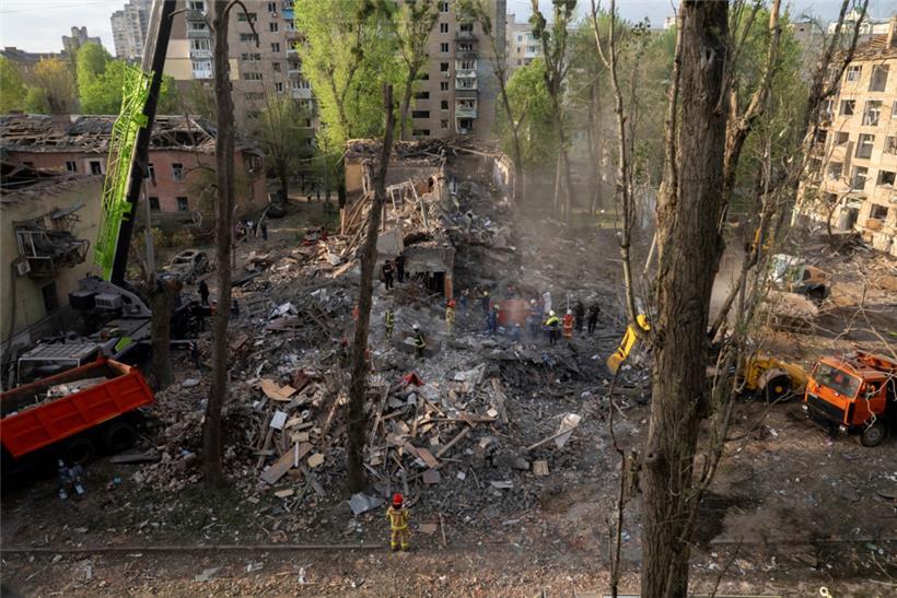 Rettungskräfte beseitigen die Trümmer nach einem russischen Angriff auf ein Wohnviertel: so viel zum Friedenswillen Putins
