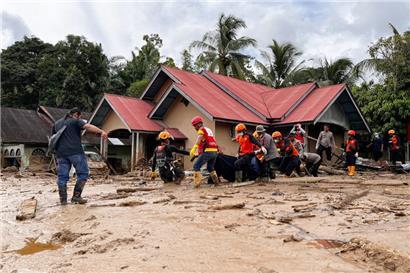 Rettungskräfte in Indonesien tragen die Leiche eines Flutopfers
