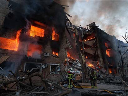 Rettungskräfte löschen Wohnhausbrand nach russischem Angriff in Kiew, Ukraine, Einsatzkräfte bei Löscharbeiten am zerstörten Gebäude