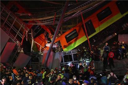 Rettungskräfte stehen am Unfallort, nachdem eine U-Bahn-Brücke zum Teil eingestürzt ist

