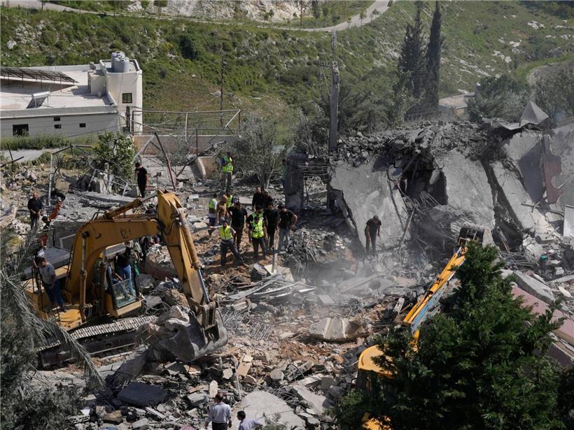 Rettungskräfte suchen nach Überlebenden in Trümmern beschädigter Häuser nach israelischem Luftangriff