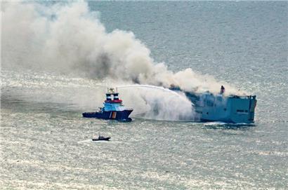 Rettungskräfte versuchen, den brennenden Frachter zu löschen und ihn am Sinken zu hindern
