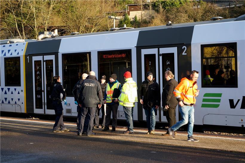 Rheinland-Pfalz, Idar-Oberstein: Polizisten und Bahnmitarbeiter stehen auf dem Bahnhof vor einem Regionalzug nach Saarbrücken. Die Bundespolizei in Idar-Oberstein hatte den Zug mit etwa 70 Fahrgästen wegen Coronavirus-Verdachts gestoppt.
