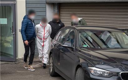 Rheinland-Pfalz, Kaiserslautern: Polizisten bringen einen der Tatverdächtigen am Dienstag (im weißen Overall) nach dem Haftprüfungstermin am Landgericht Kaiserslautern aus dem Justizgebäude
