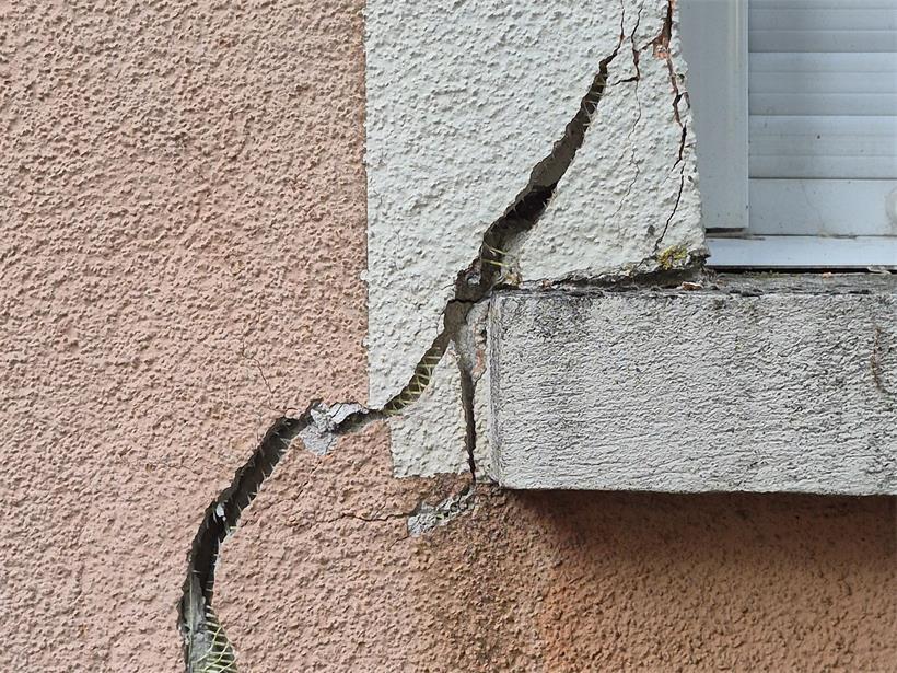 Risse ziehen durch die Fassade eines Mehrfamilienhauses