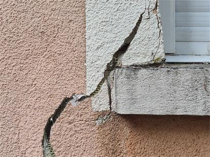 Risse ziehen durch die Fassade eines Mehrfamilienhauses