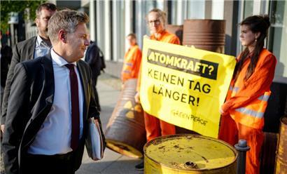 Robert Habeck (Bündnis 90/Die Grünen), Bundesminister für Wirtschaft und Klimaschutz, geht auf dem Weg zur Pressekonferenz zu den Ergebnissen des Stresstests zum Weiterbetrieb von Atomkraftwerken an Greenpeace-Protestlern vorbei
