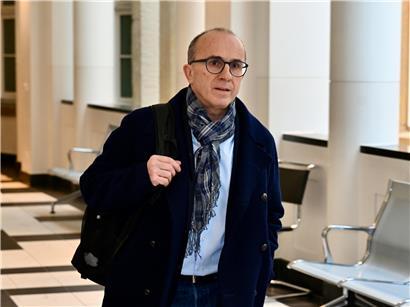 Roberto Traversini spricht vor dem Palais de Justice, formell gekleidet bei einer Pressekonferenz