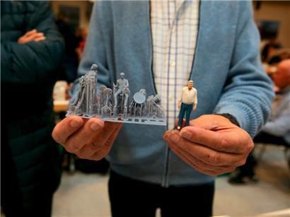 Roger zeigt die Miniaturfiguren, wie sie frisch aus dem 3D-Drucker kommen: Rechts eine zur Hälfte fertig gemalte Figur
