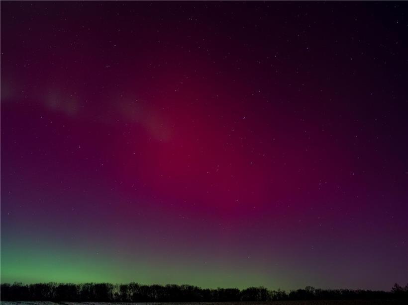 Nachthimmel über Deutschland in roten und grünen Farbtönen mit leuchtenden Nordlichtern und Sternenhimmel
