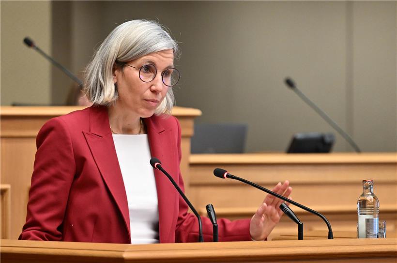 Porträt von Sam Tanson, Politikerin der Grünen Partei Luxemburgs, vor neutralem Hintergrund