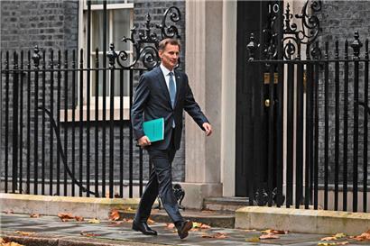 Schatzkanzler Jeremy Hunt auf dem Weg zum House of Commons, wo er den Abgeordneten seinen Nachtragshaushalt vorstellt
