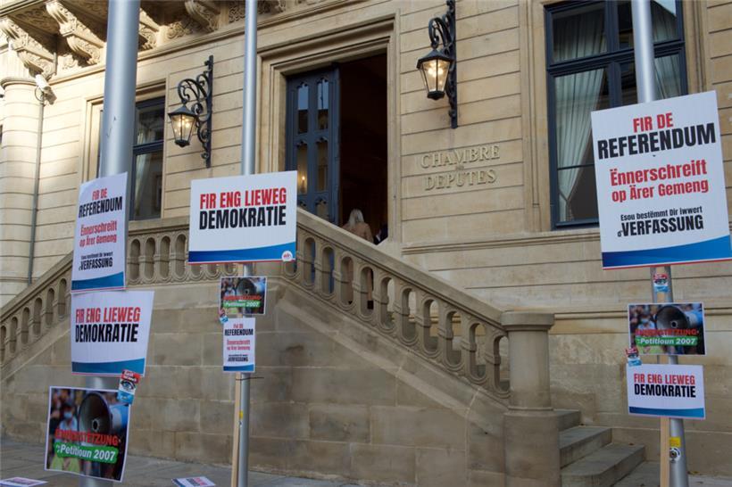 Schilder vor dem Luxemburger Parlament bei einer Protestaktion am 25. November 2021
