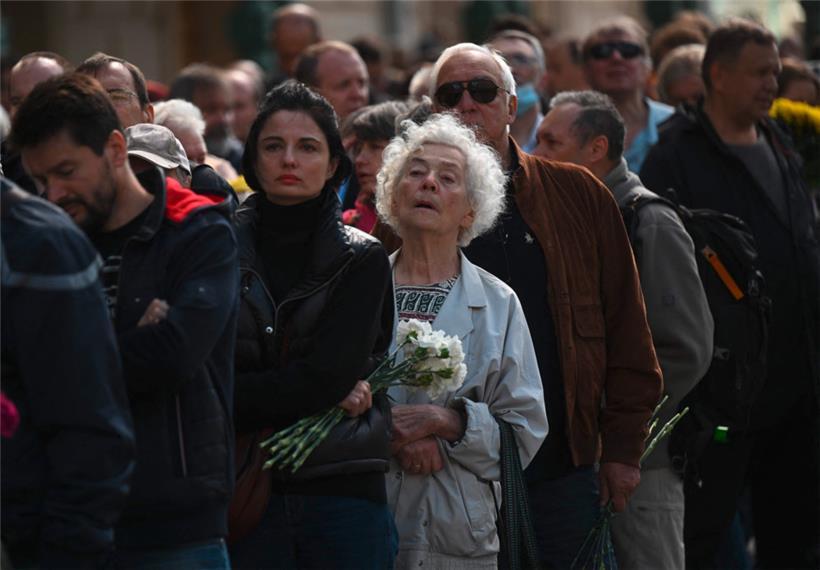„Schrecklich dunkle Zeiten“: Menschen warten, um Blumen niederlegen zu können
