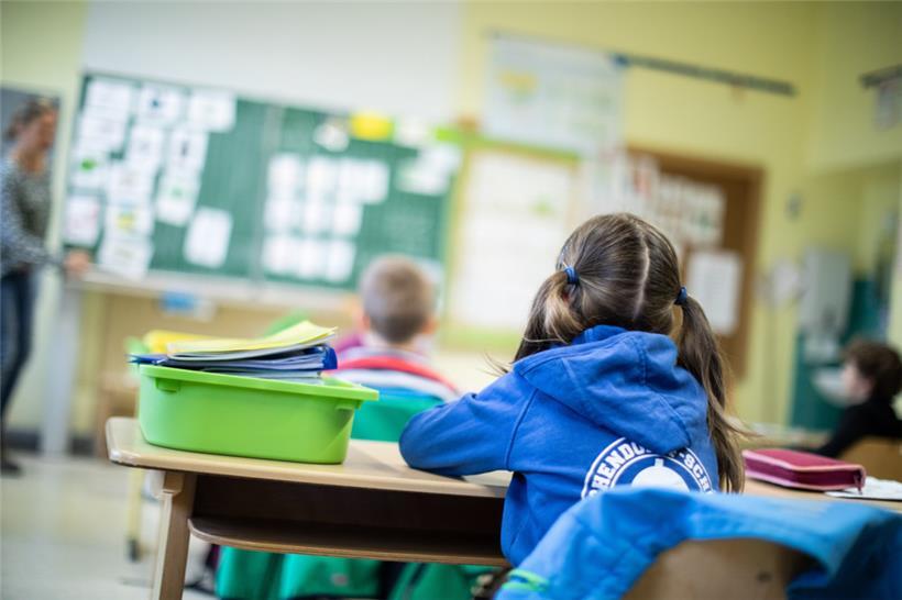 Schülerinnen und Schüler einer Grundschule sitzen in ihrem Klassenraum
