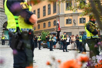 Schwedische Polizisten schirmten gestern die beiden „Aktivisten“, die nicht im Bild zu sehen sind, während deren „Protest“ ab
