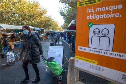 Schweiz, Carouge: Ein Schild mit der Aufschrift „Hier Gesichtsmaske obligatorisch“ steht auf einem Wochenmarkt bei Genf
