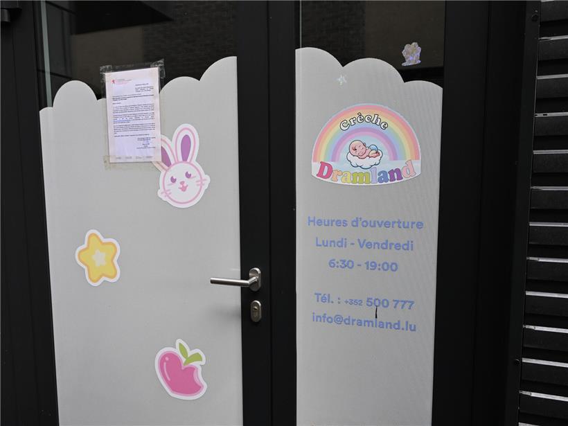 Kinderkleidung hängt zum Trocknen in einer Kita-Garderobe, bunte Jacken und Mützen sichtbar