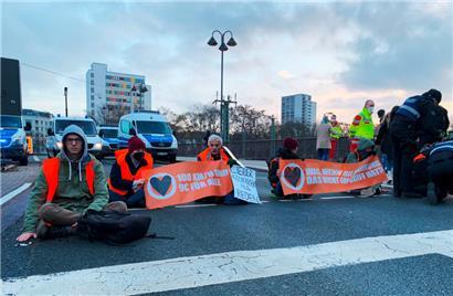  Sechs Aktivisten der Gruppe „Letzte Generation“ haben sich auf einer mehrspurigen Straße am Hauptbahnhof in Mainz mit einer Hand auf dem Asphalt festgeklebt
