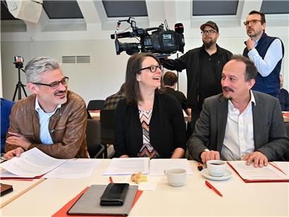 David Wagner, Carole Thoma und Marc Baum stehen selbstbewusst und angriffslustig nebeneinander in Business-Kleidung