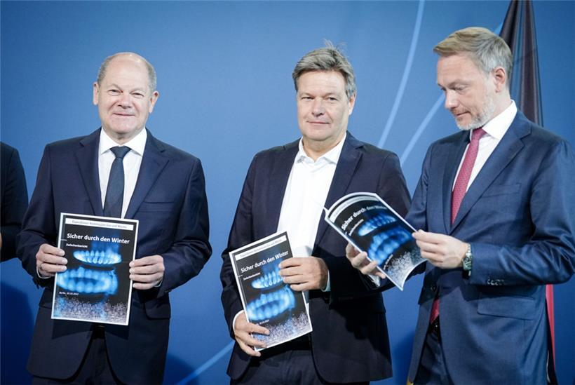 „Sicher durch den Winter“ steht auf dem Deckblatt eines Berichts, den Olaf Scholz, Robert Habeck und Christian Lindner in den Händen halten. Allerdings gibt es noch erhebliche Meinungsunterschiede zwischen den drei darüber, was dazu getan werden muss.
