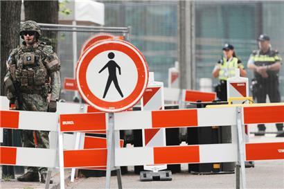 Sicherheitskräfte patrouillieren hinter einer Absperrung um den Veranstaltungsort des NATO-Gipfels in Den Haag
