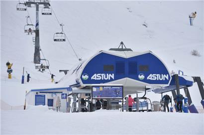 Skifahrer fahren im Jahr 2020 mit dem Sessellift im Skigebiet Astun
